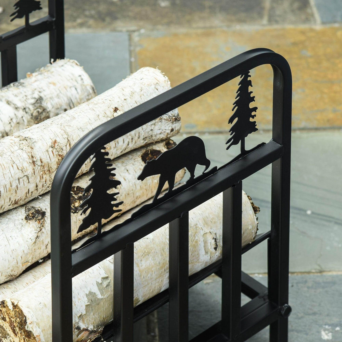Black log rack detail with bear and tree cutout design on the side rails.