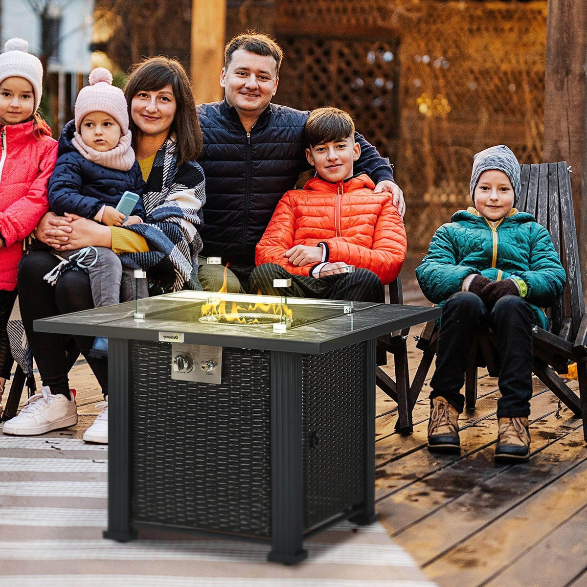 Outdoor gas fire pit table with dark rattan sides, clear glass top, marble-style desktop