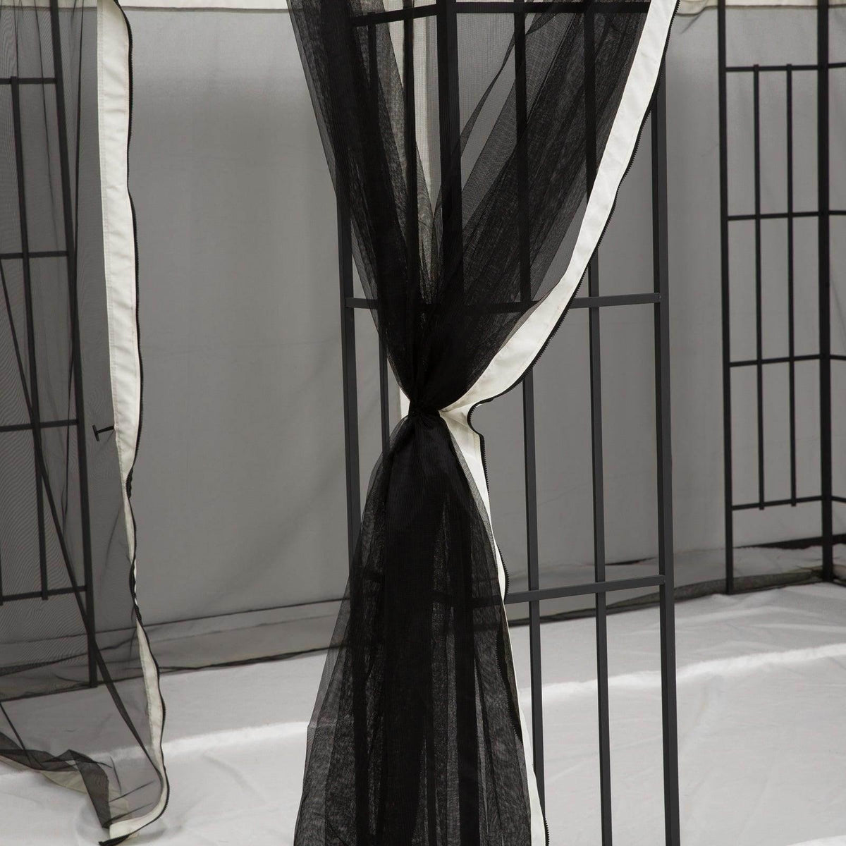 Gazebo mesh curtain panel with black net and white border tied open