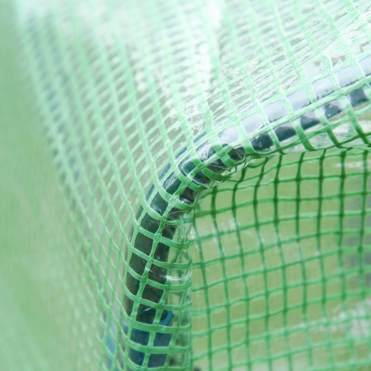 Green mesh greenhouse corner with stitched netting and frame edge