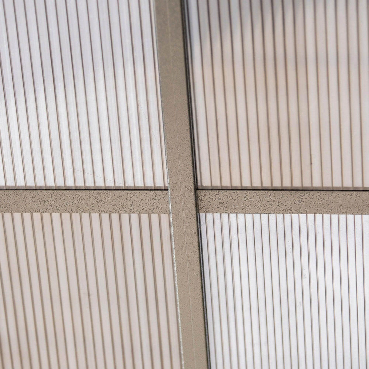 Close-up of vertical support post and gray curtain wall panels on gazebo