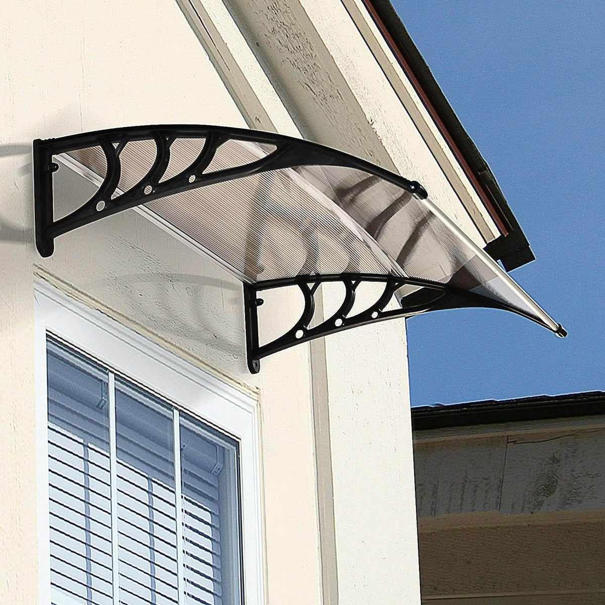 Door canopy with brown translucent panel and black curved mounting bracket