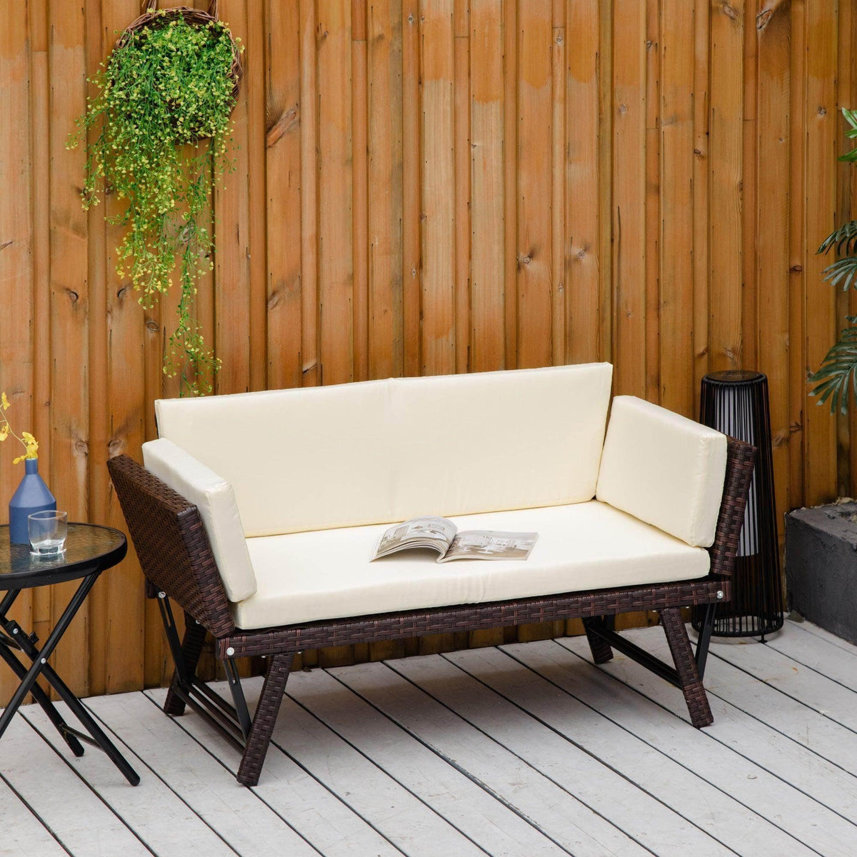 Outdoor folding rattan daybed sofa bench with white seat cushions and dark wicker frame