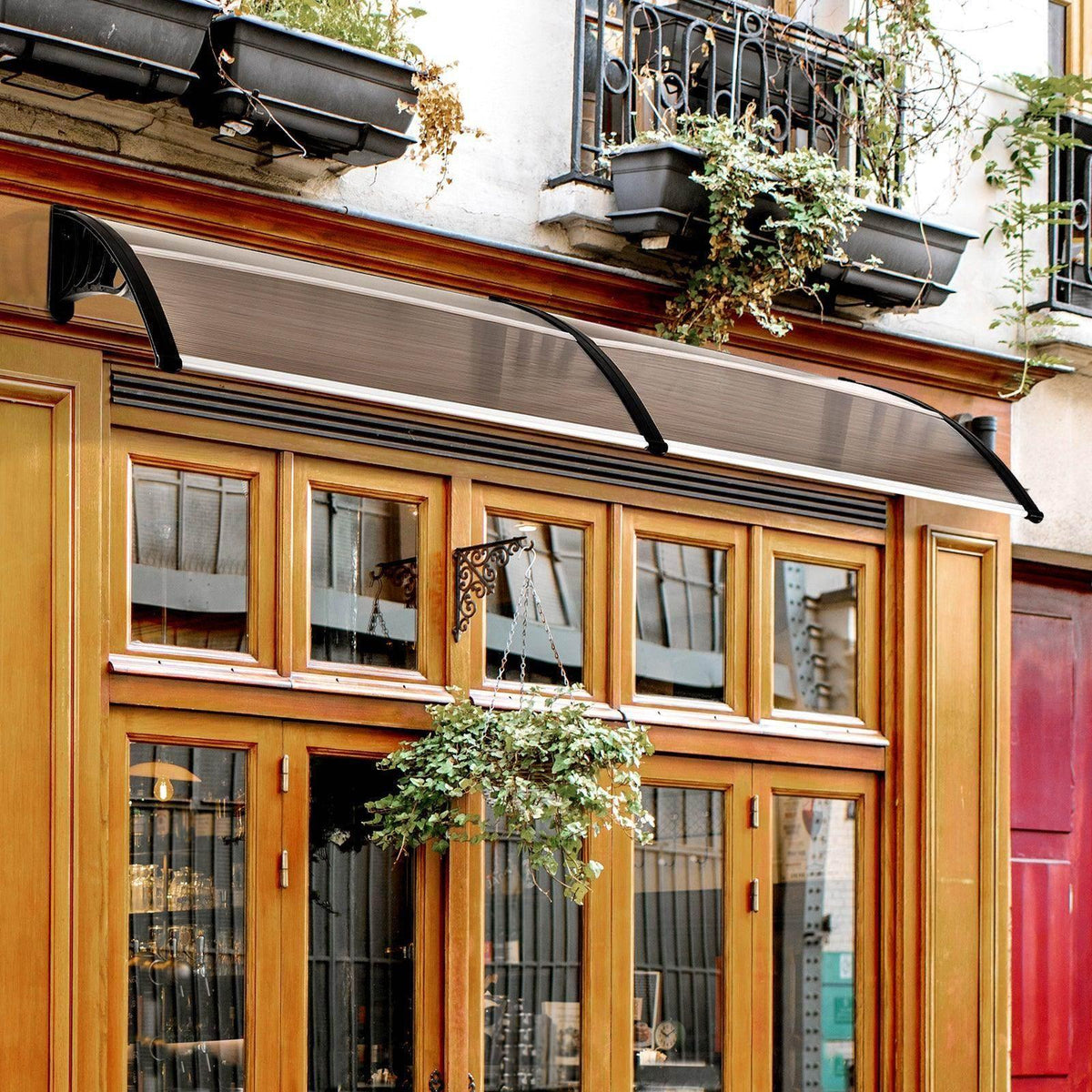 Brown translucent outdoor patio awning canopy with black frame mounted above windows
