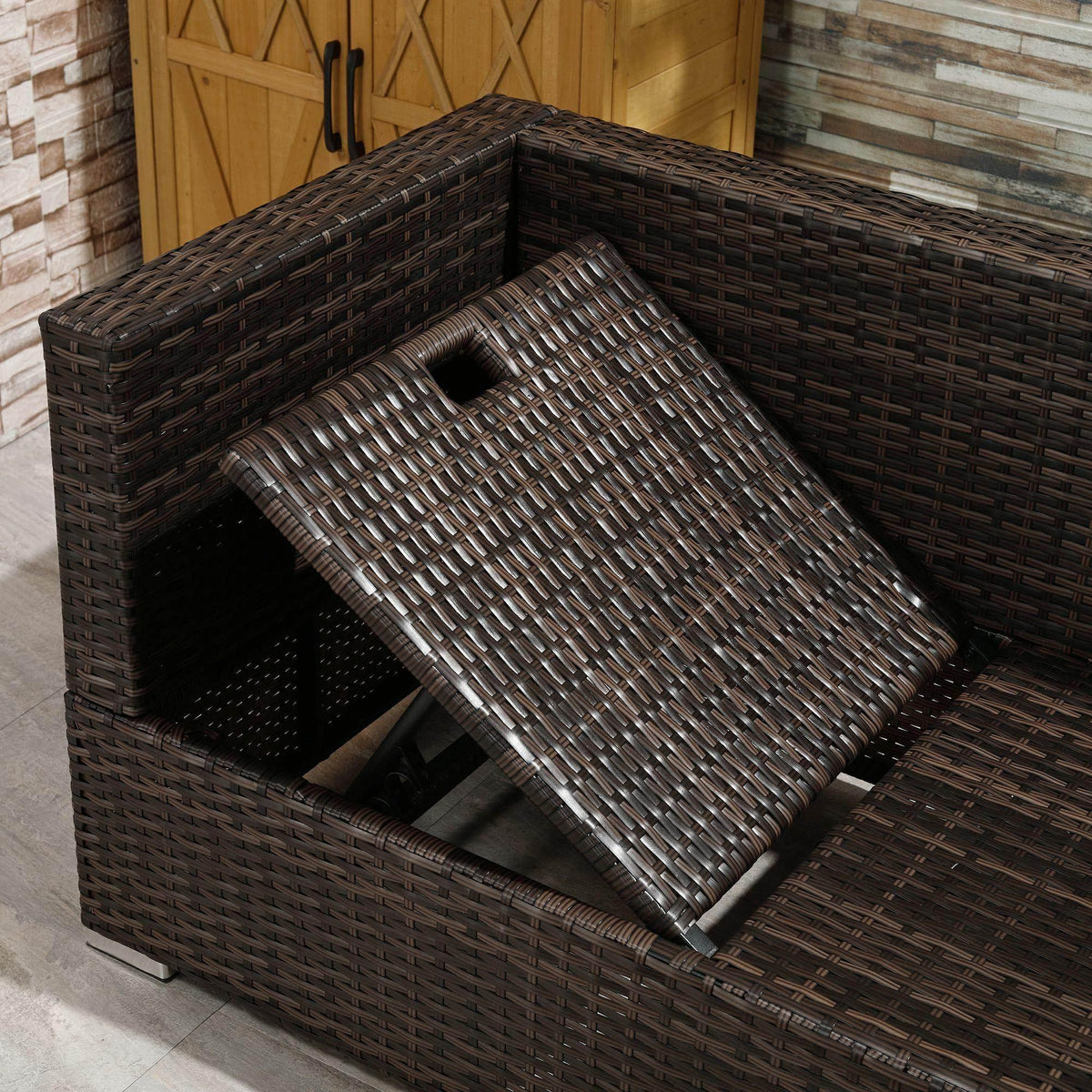 Outdoor rattan storage ottoman with woven lid open, showing empty interior