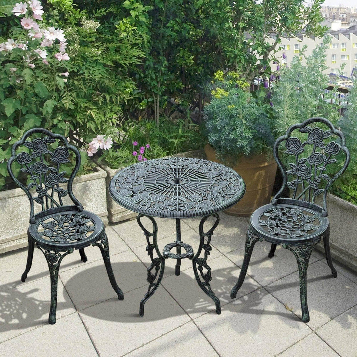 Dark green round cast-metal bistro table with two matching ornate chairs