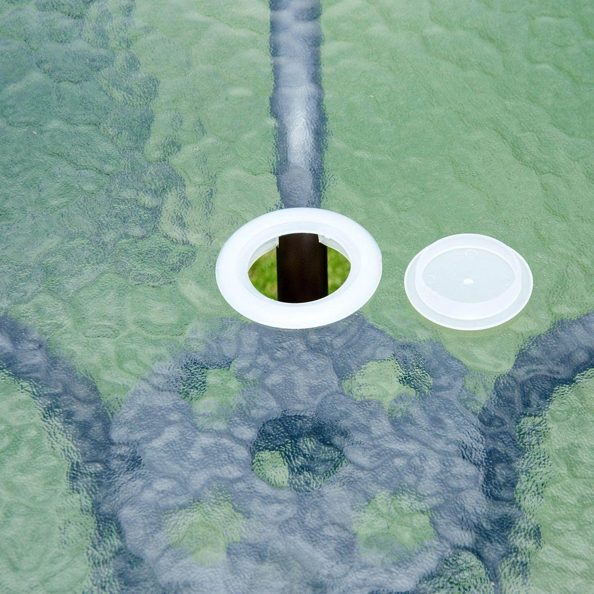 Two white circular umbrella anchors floating on water