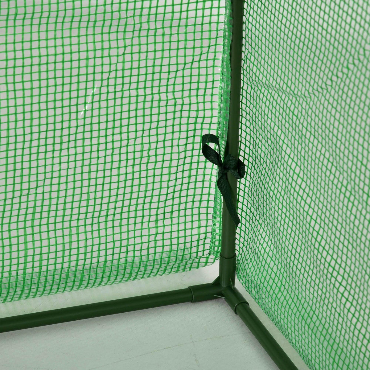 Close-up of green greenhouse mesh fabric corner with tied fastening strap