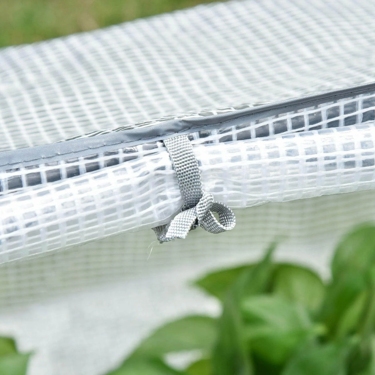 Portable greenhouse corner tie with stitched edge on gray mesh cover