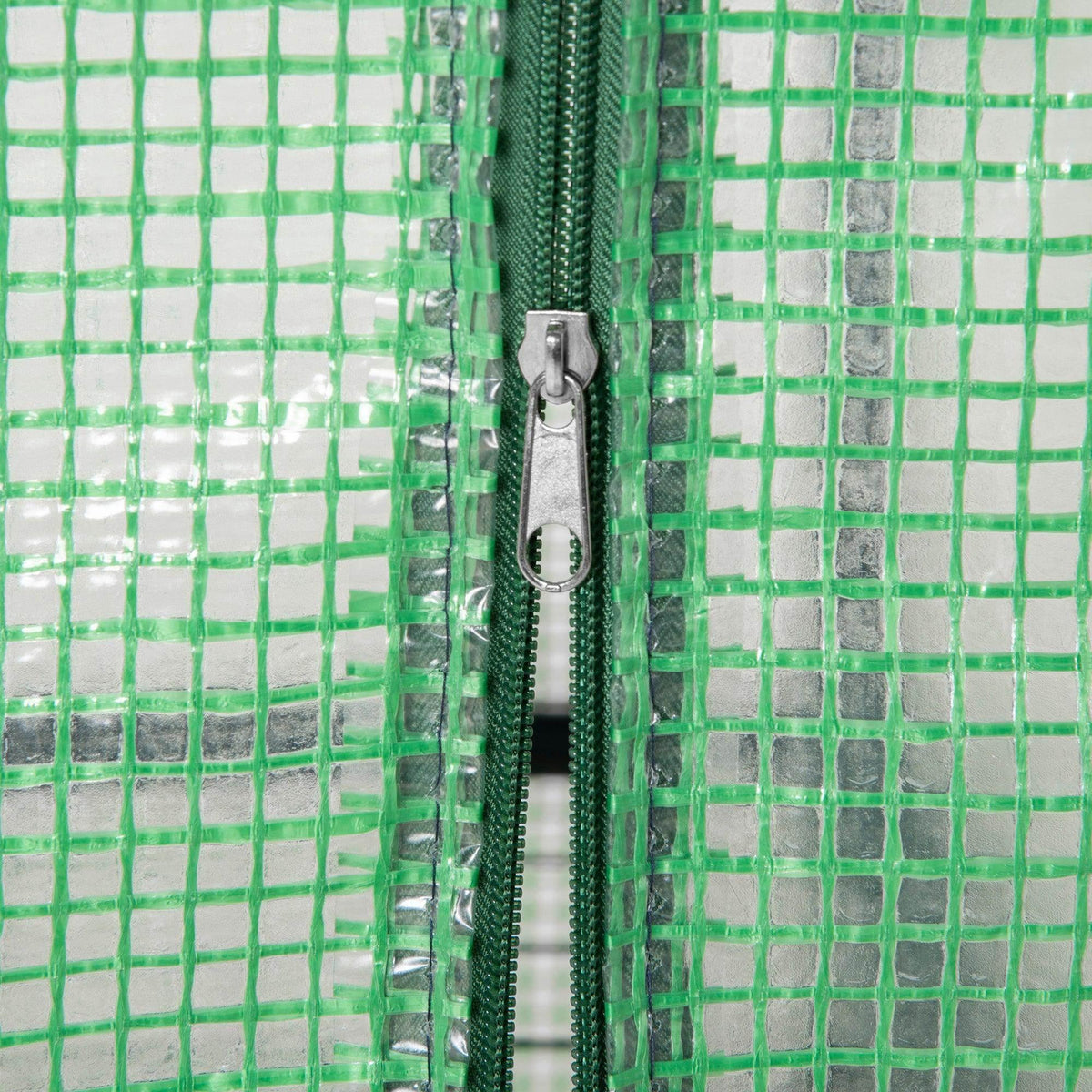 Close-up of green greenhouse door zipper on PE cover with metal frame edges