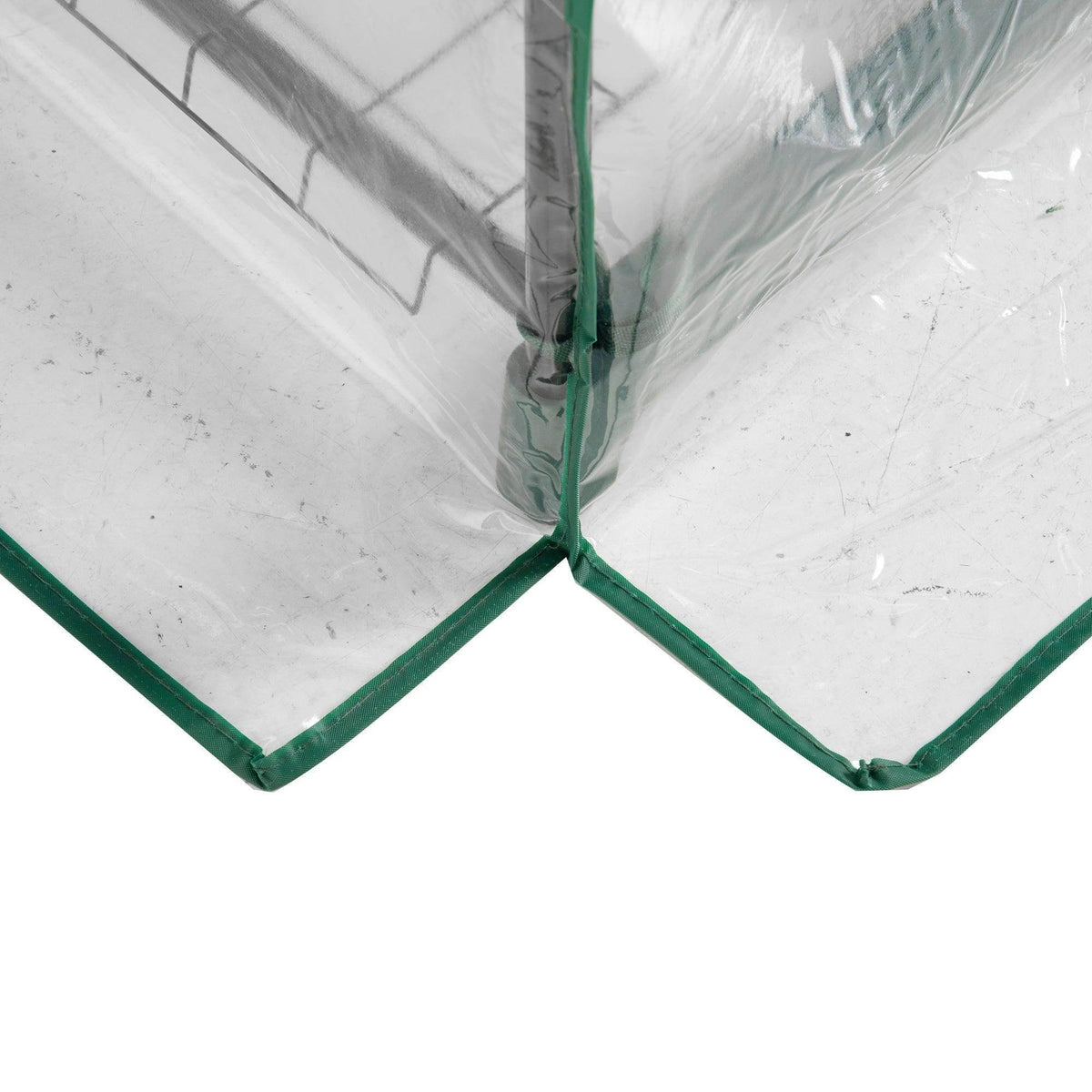 Corner joint of a green metal greenhouse frame with clear plastic cover panels
