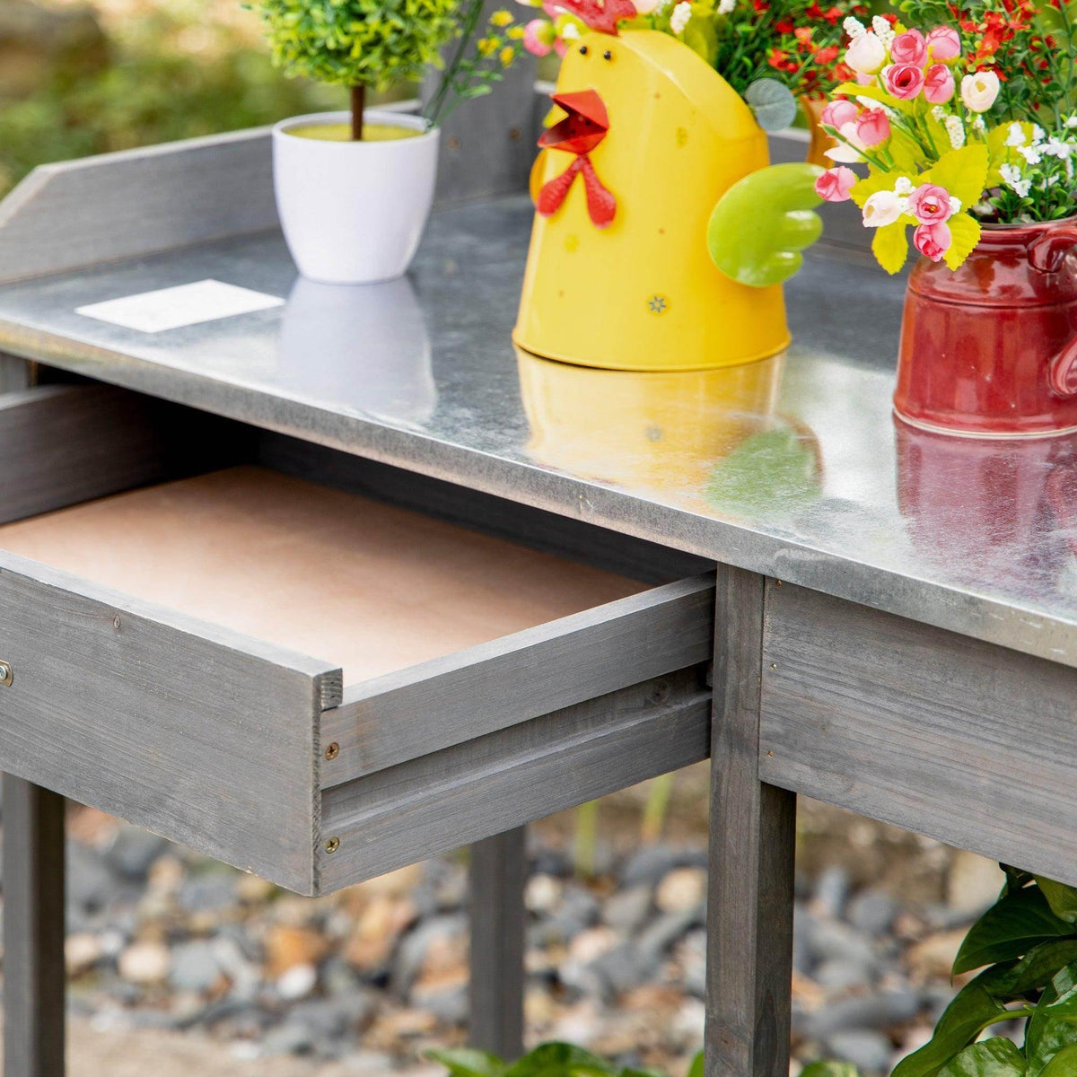 Gray metal tabletop potting area with raised edges and built-in lower shelf