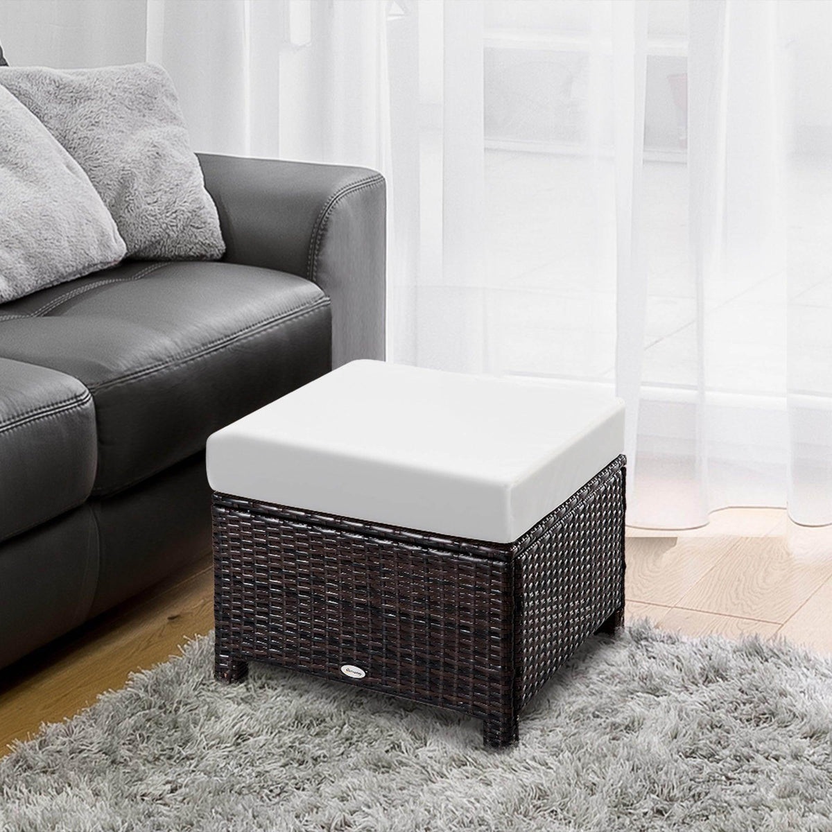 Brown rattan ottoman with white cushion, woven storage-style sides and low legs.