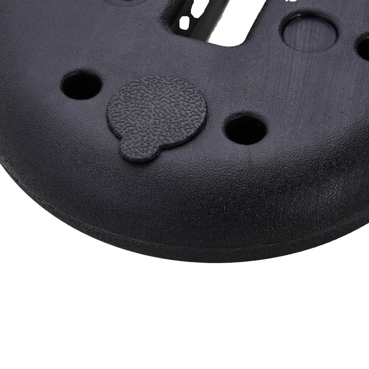 Close-up of black textured weight plate surface with circular grip pad and pole-hole ports