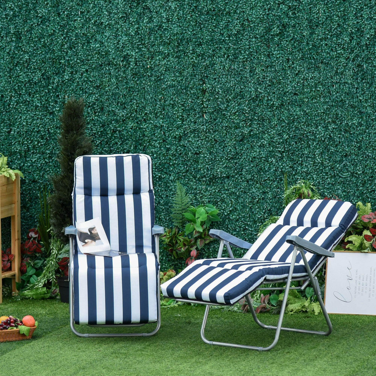 Navy and white striped outdoor lounge chairs on artificial grass with green hedge backdrop