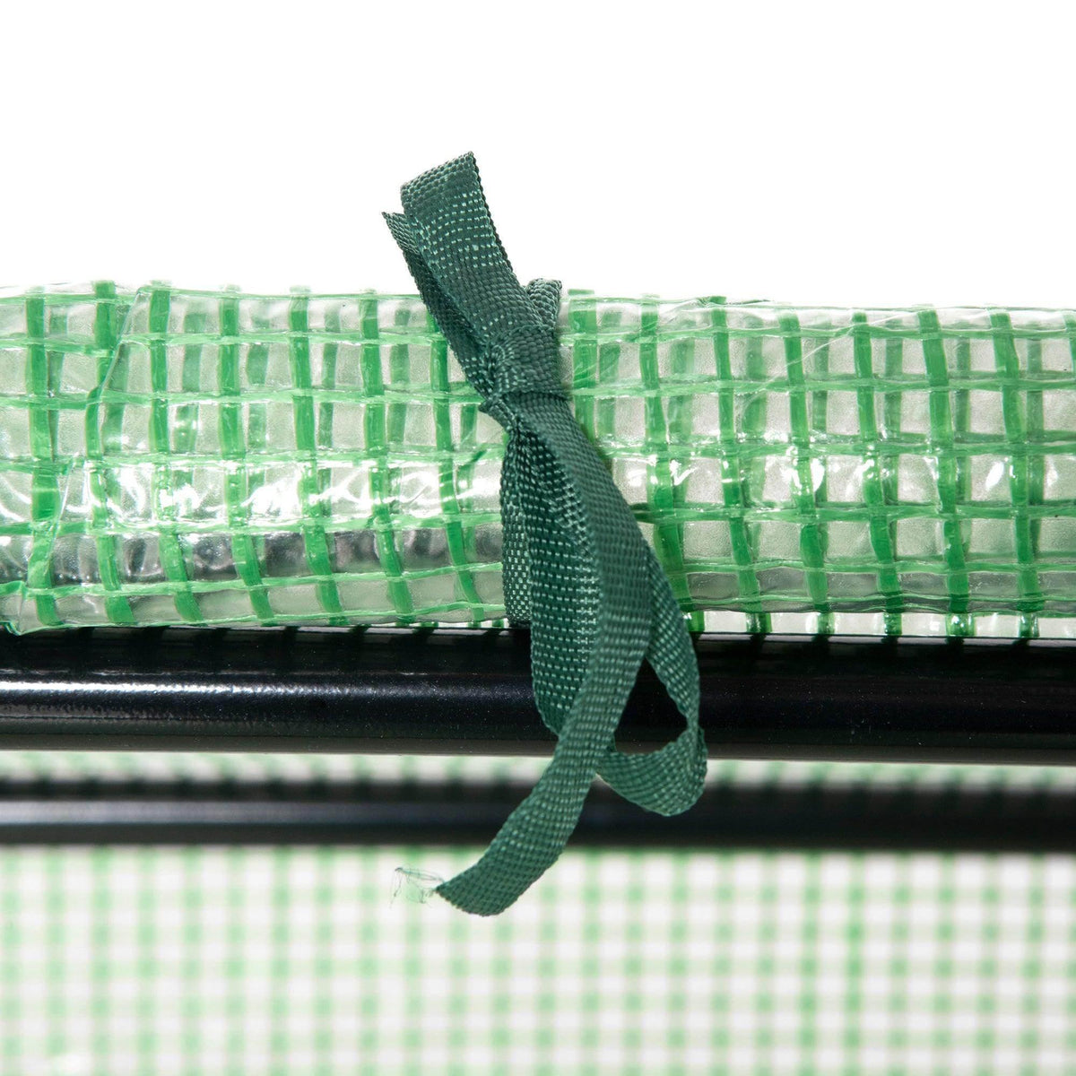Close-up of green mesh greenhouse strap tied to the cover window frame