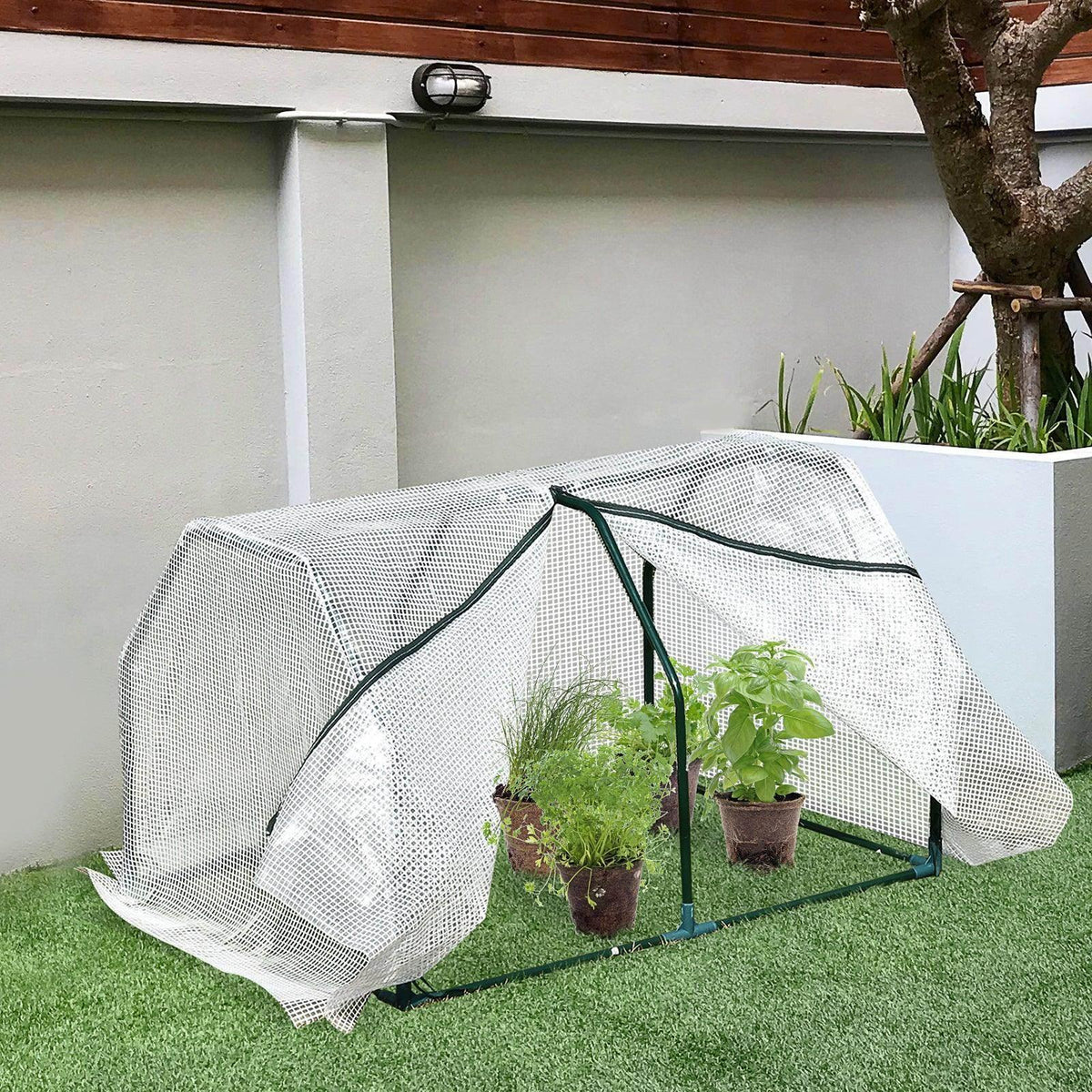 Small portable greenhouse with white mesh cover and green steel frame over potted plants
