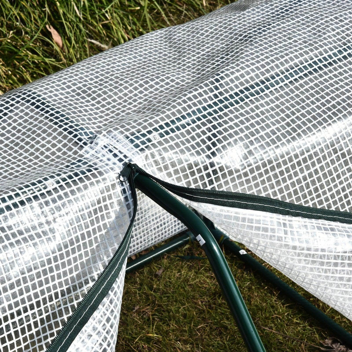 Close-up of white mesh greenhouse cover secured to a green frame bar