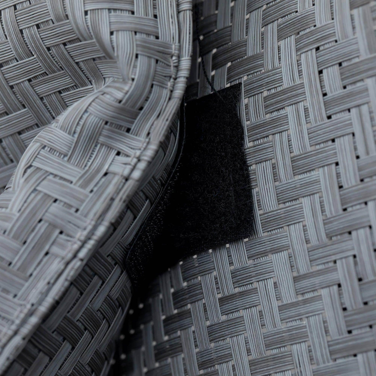 Grey woven rattan-effect fabric close-up with black underside trim