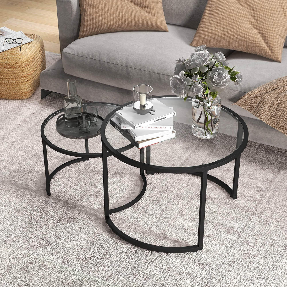 Two round black glass nesting coffee tables with steel frames in living room
