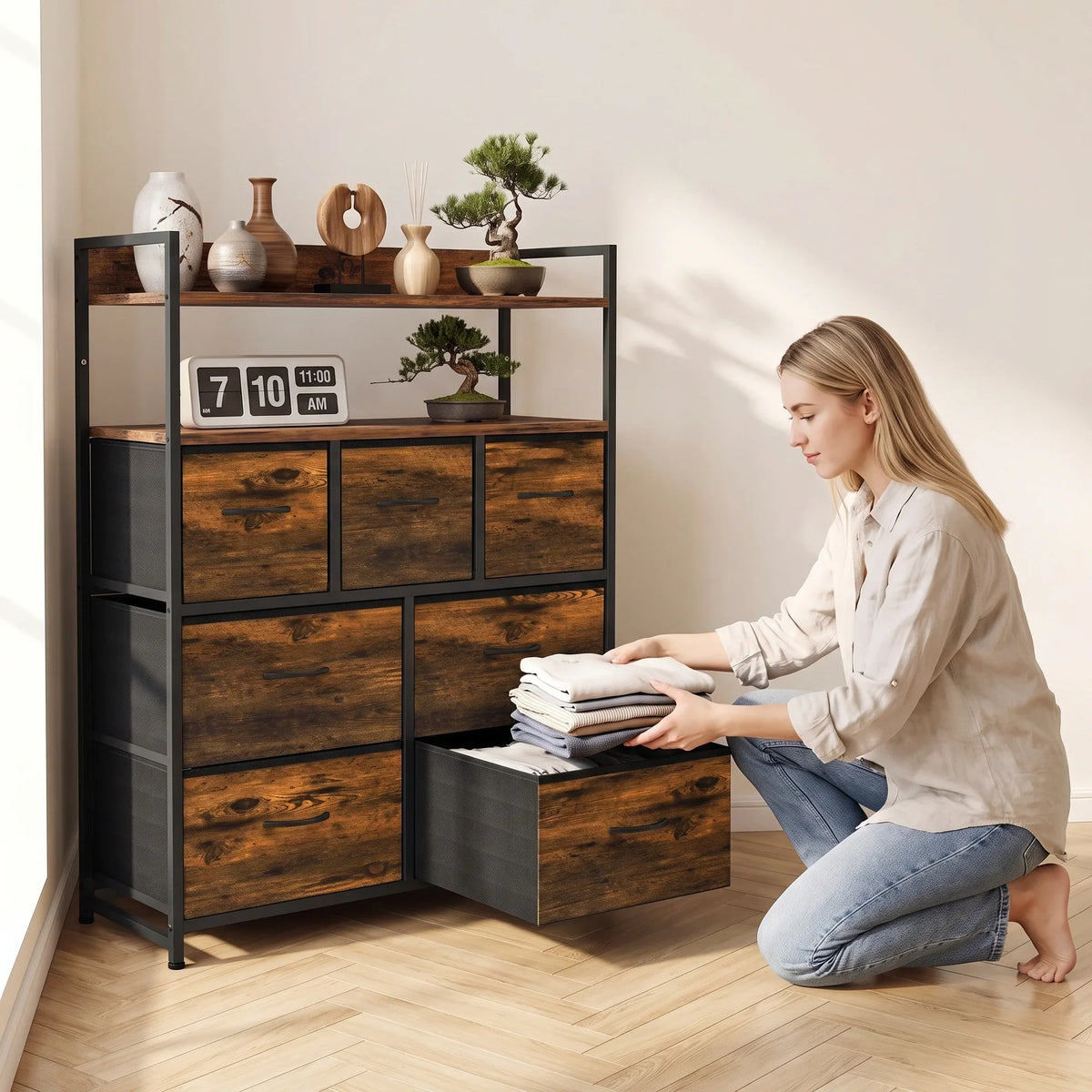 Rustic brown dresser with open shelves and drawers, with person organizing linens