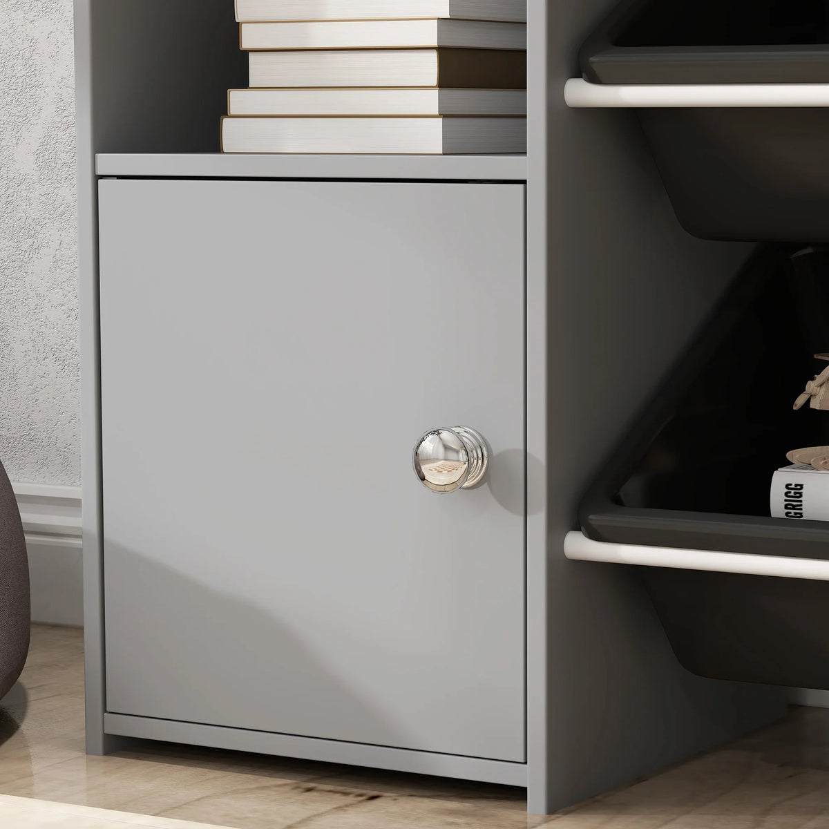 Grey cabinet door with round knob and adjacent open storage bins