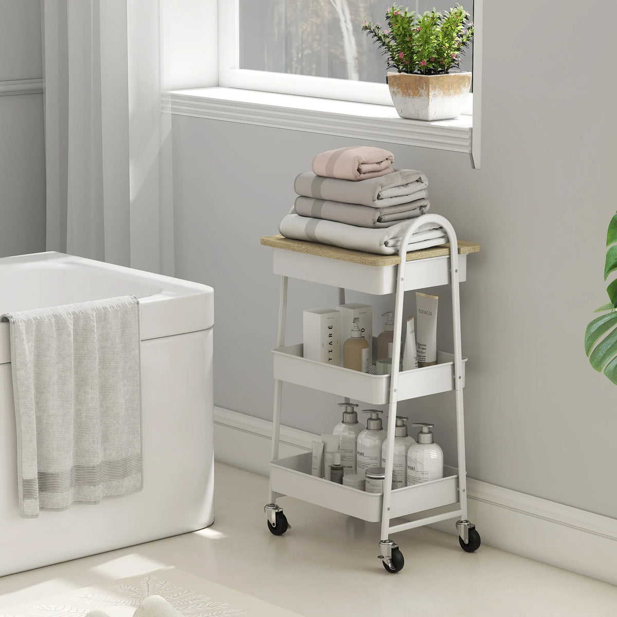 White 3-tier kitchen trolley with oak top board, shelves for towels and bottles, casters.