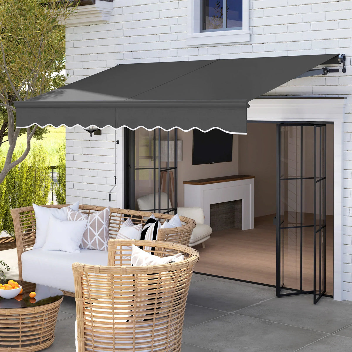 Electric retractable awning with dark gray fabric and aluminum frame over patio door