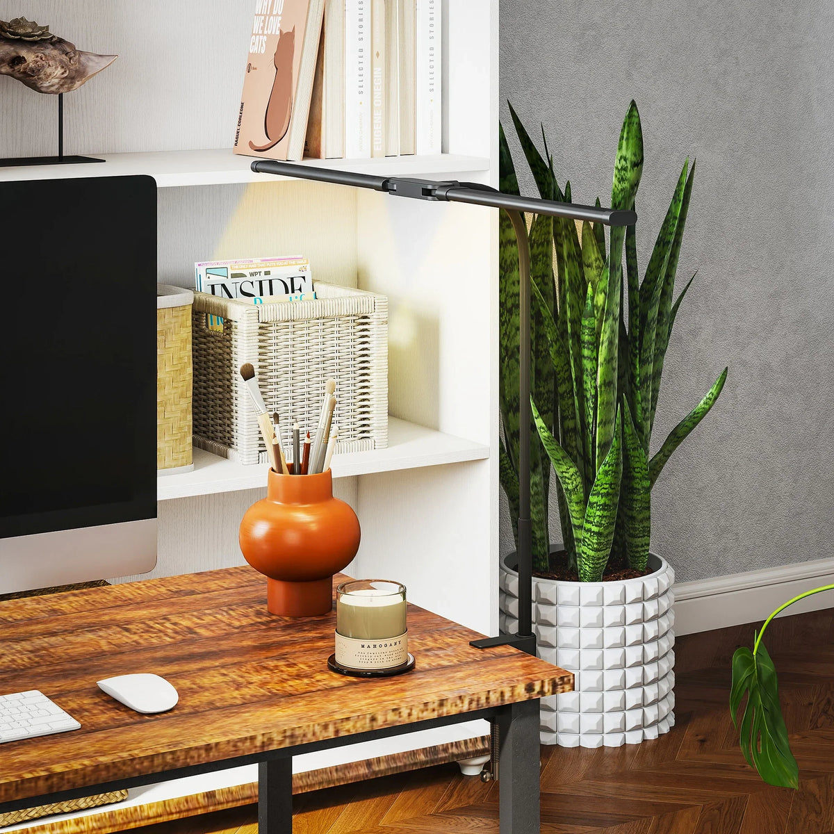 Black LED desk clamp lamp with extended arms over home office shelving