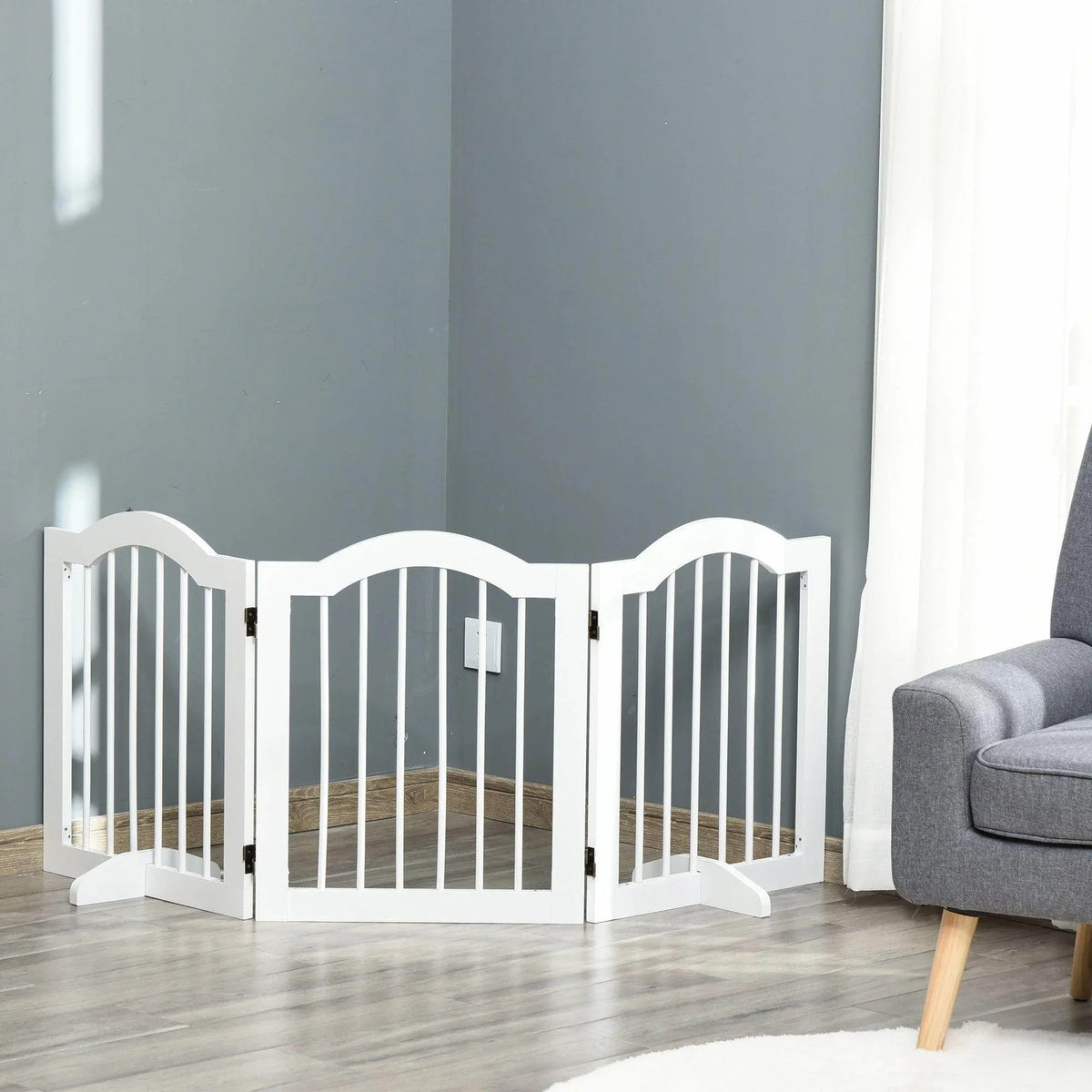 White foldable pet gate with freestanding hinged panels and vertical bars