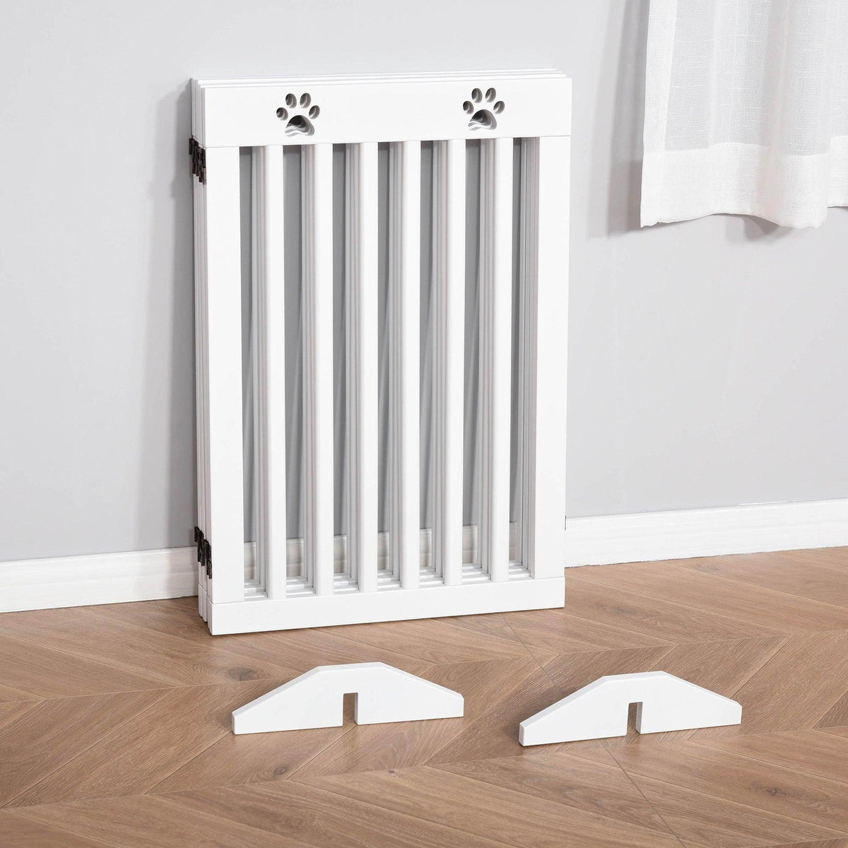 White pet gate with paw-print top cutouts and vertical bars for doorway blocking