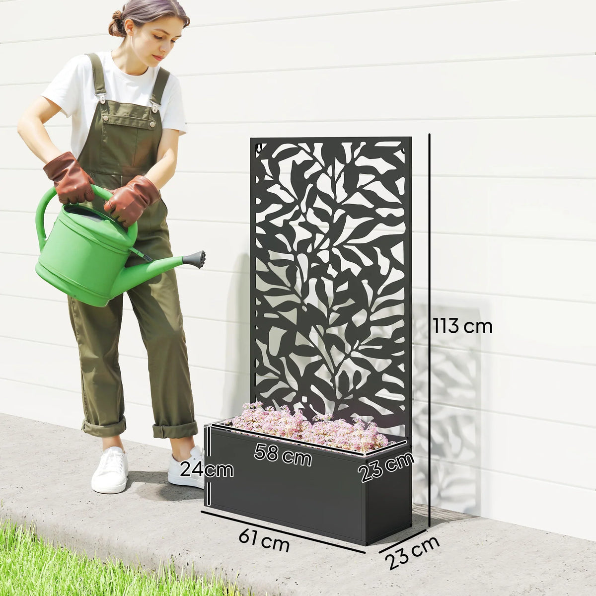 Black metal raised planter with cutout trellis privacy panel, shown beside a person