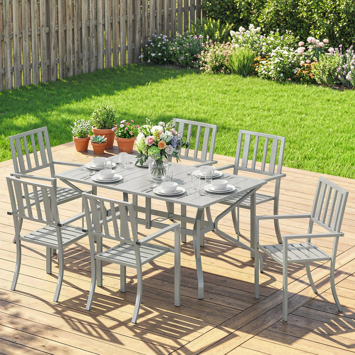 Light grey 6-seater outdoor dining table with six slat chairs and center flowers