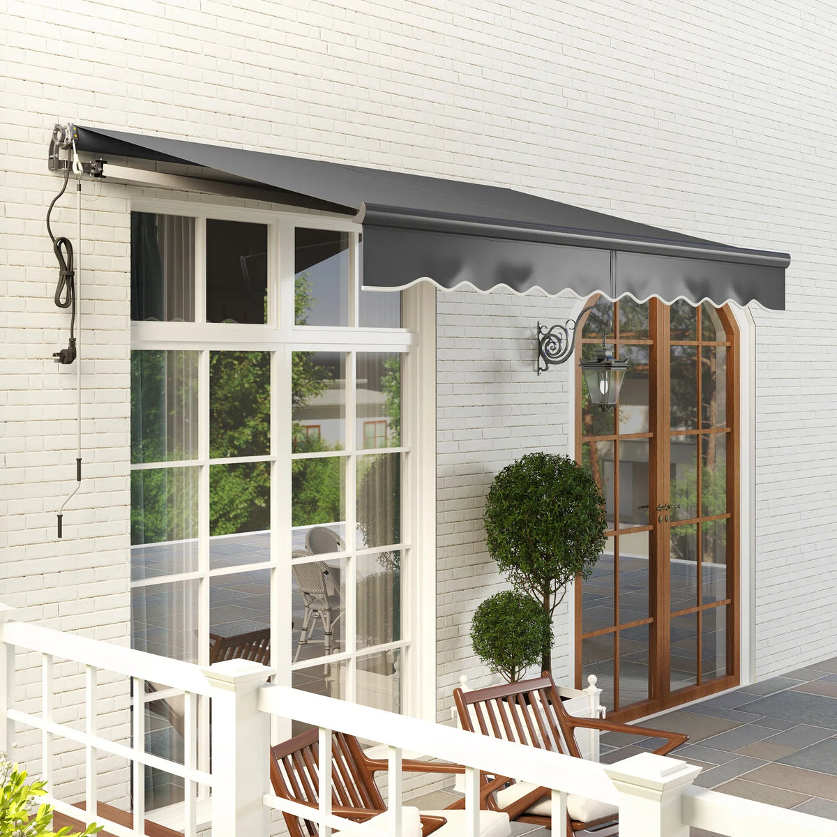 Retractable awning over windows with dark gray canopy and scalloped valance