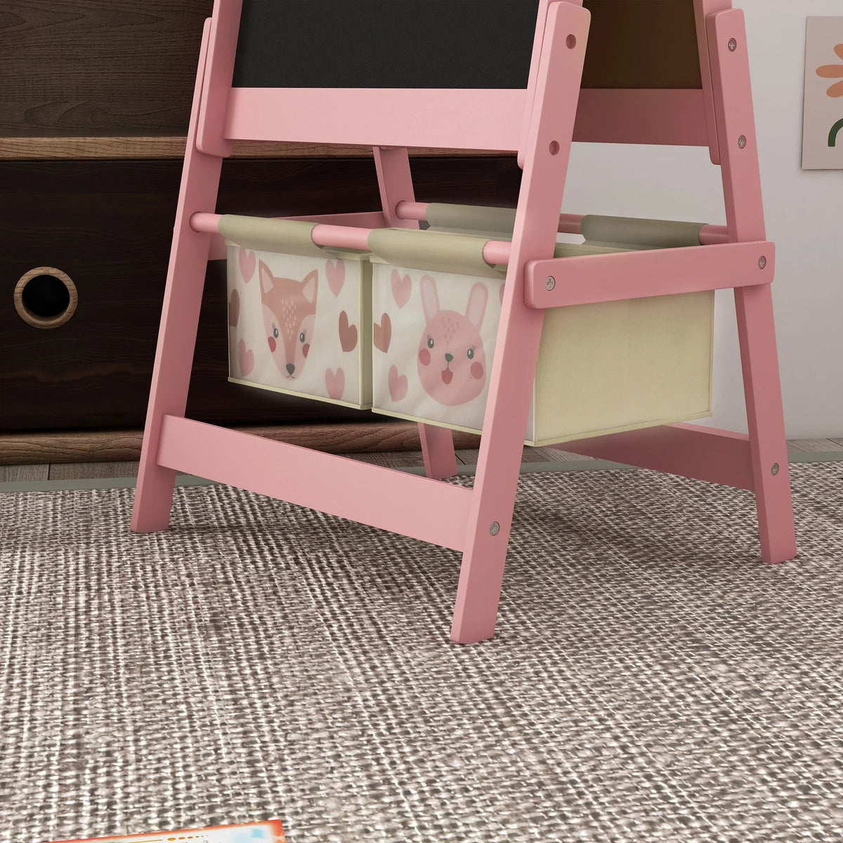 Pink kids easel showing front storage bins with bunny print panels