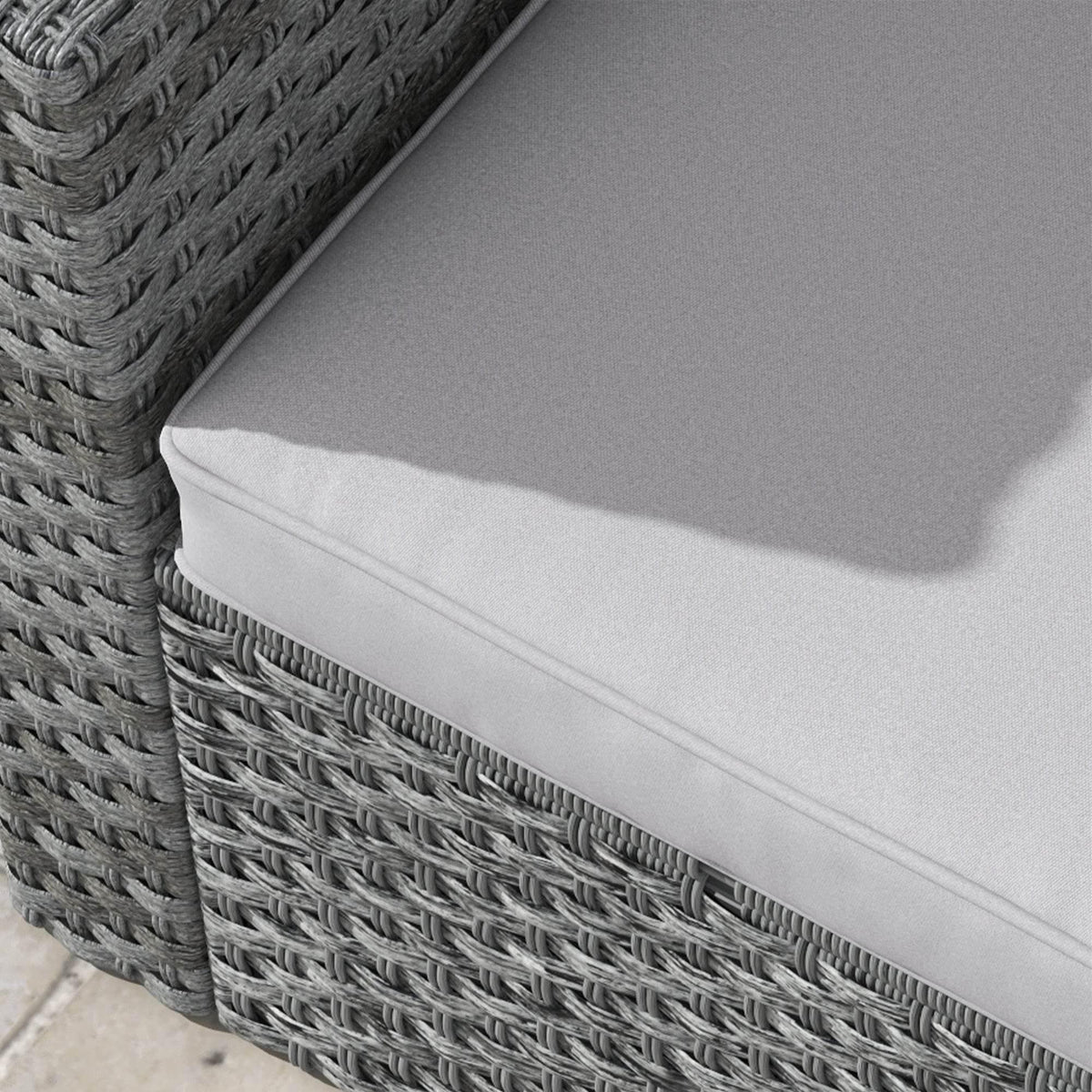 Light grey seat cushion with piped edge on woven dark grey chair