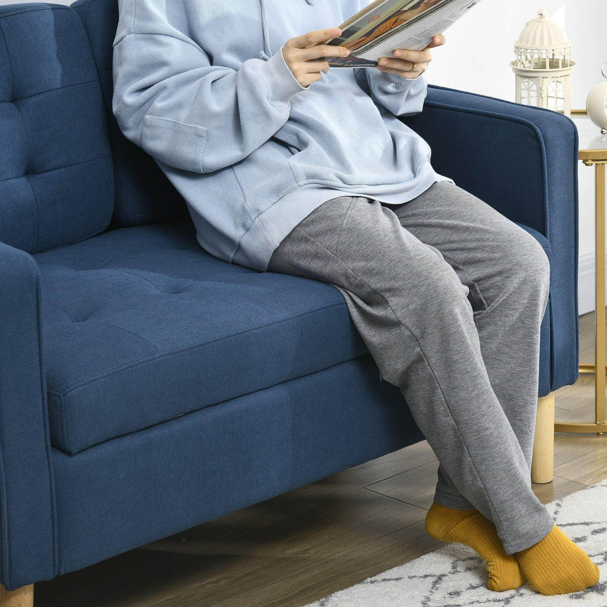 Blue upholstered loveseat sofa with padded seat and wide armrests, close-up