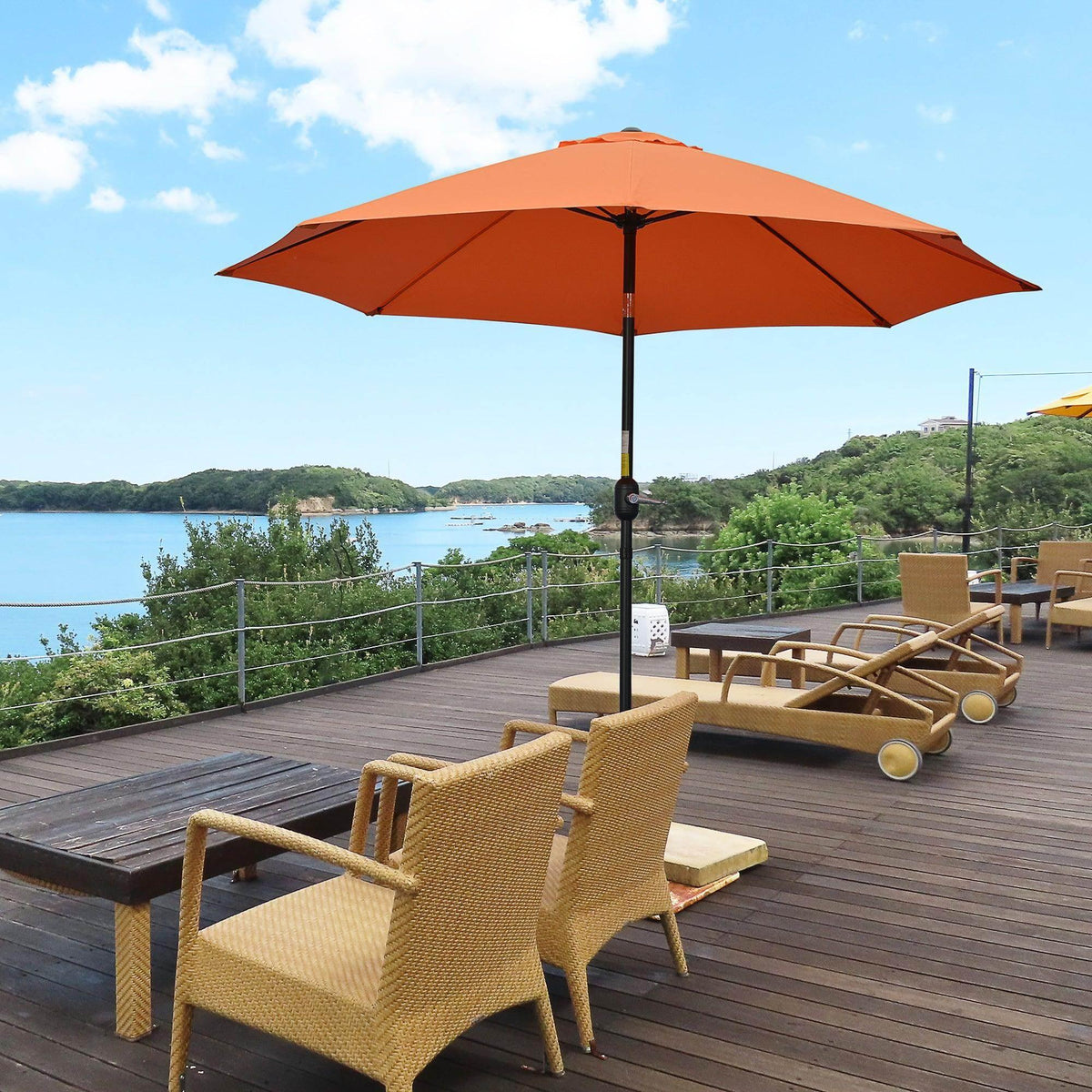 Orange patio umbrella with black pole and open canopy over outdoor seating