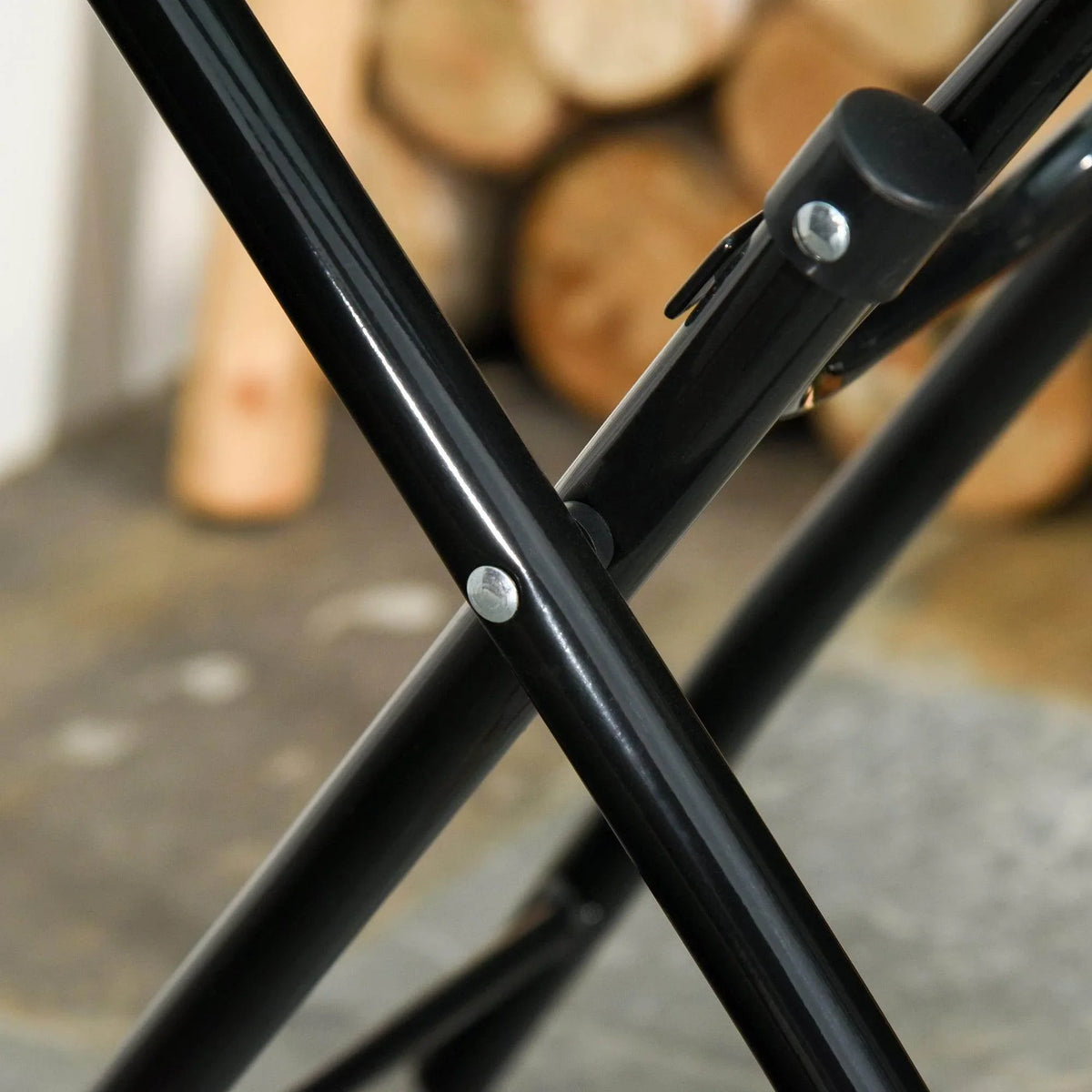 Black metal folding table leg joint with bolts on X-shaped frame
