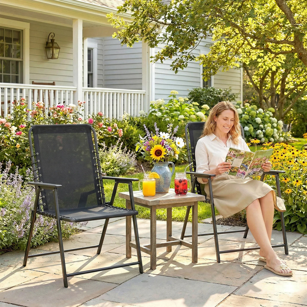 Black folding garden chair with high mesh back, armrests, and wide texteline seat