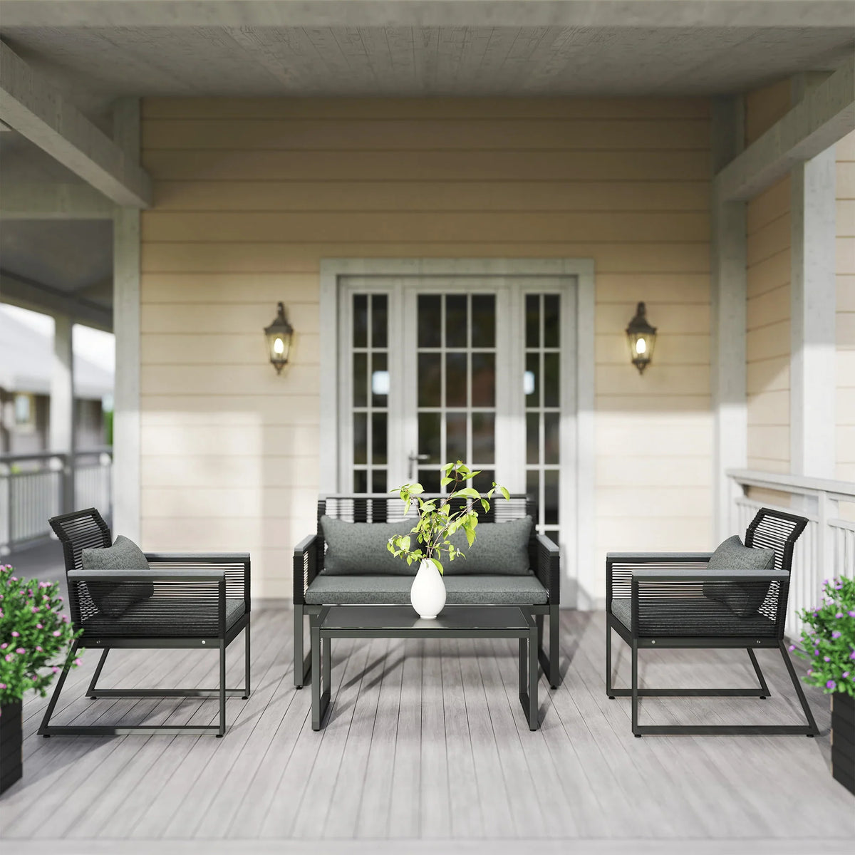 Charcoal grey loveseat flanked by armchairs with square coffee table on covered porch