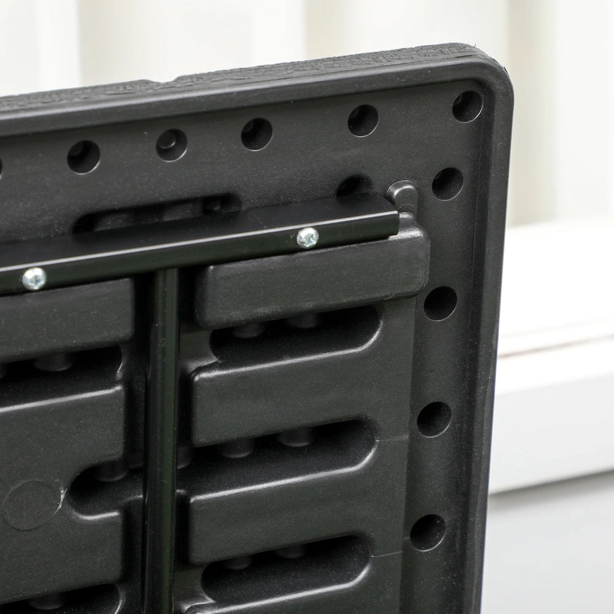 Black plastic storage box latch area with metal support bar