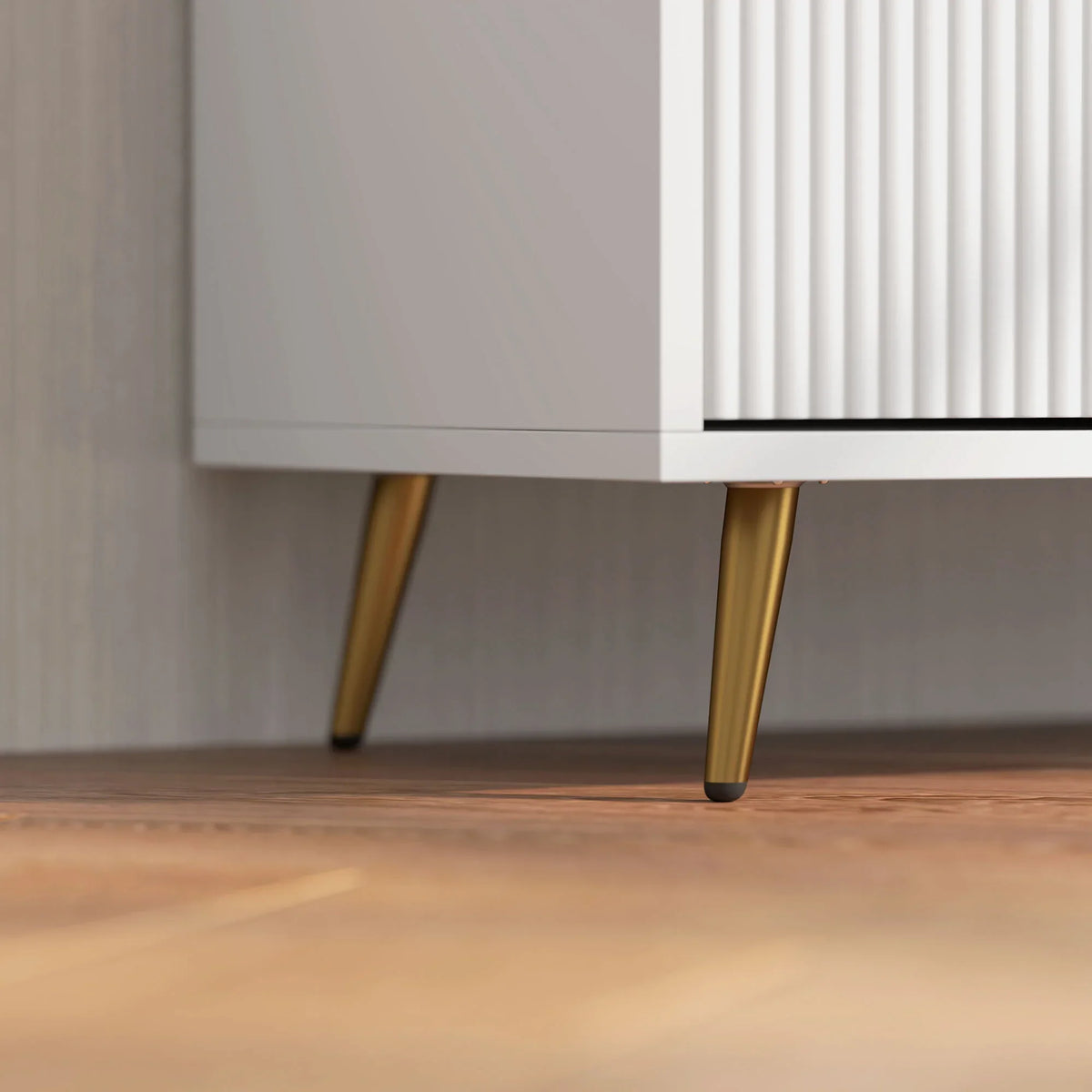 White TV stand close-up: gold-tone tapered legs