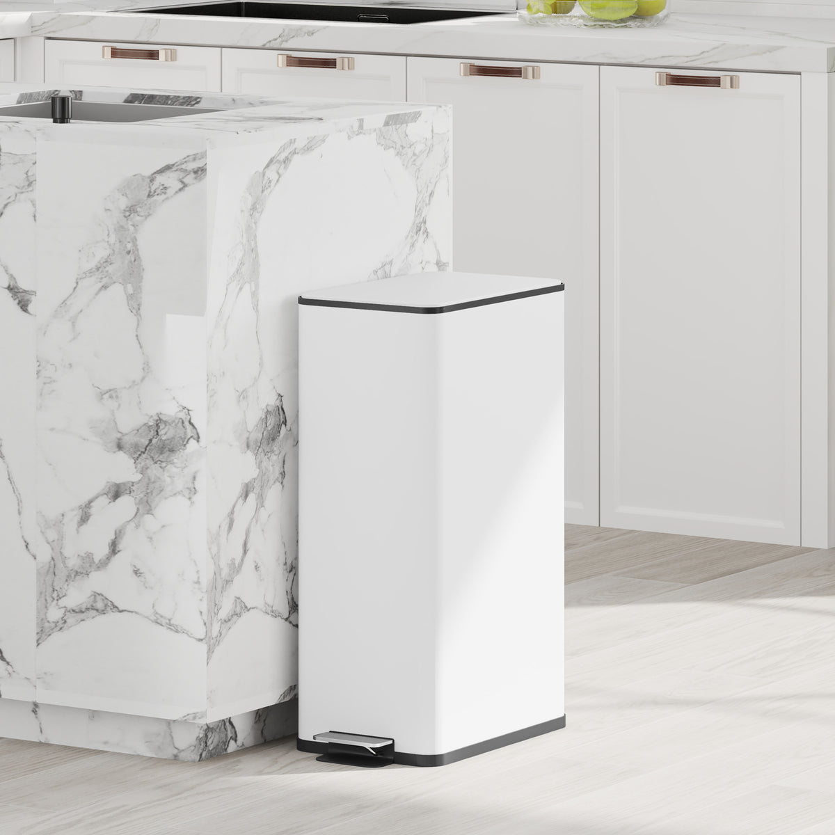 White slim pedal trash bin standing in a kitchen next to marble cabinet