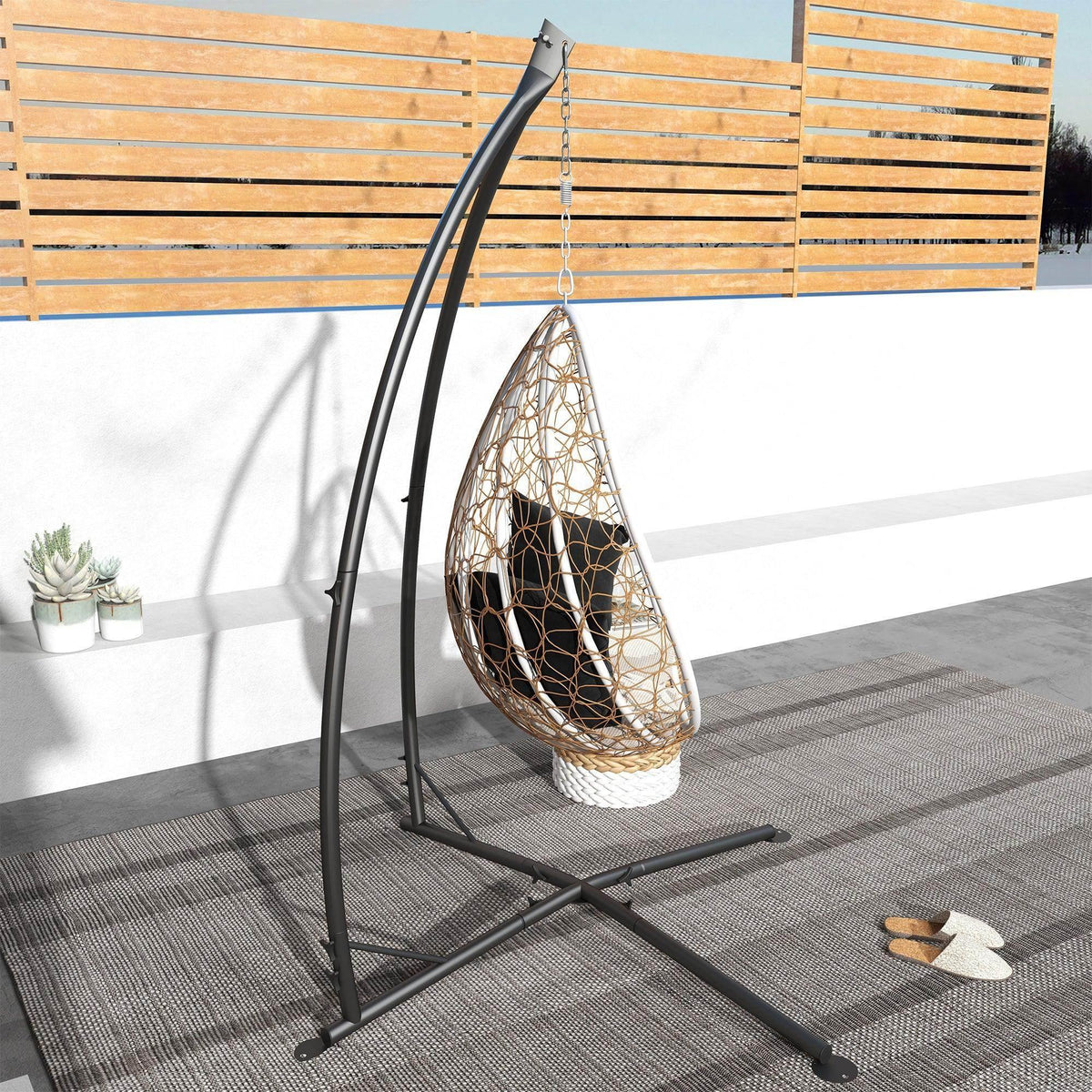 Black hammock chair stand with suspended egg-style mesh hammock seat on metal base