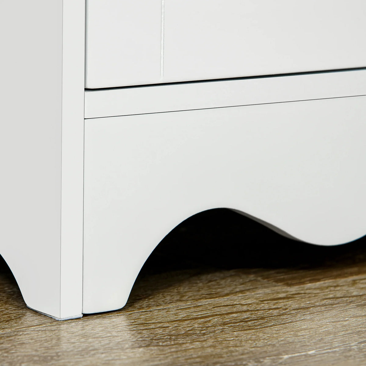 White cabinet base with scalloped curved feet on wood floor