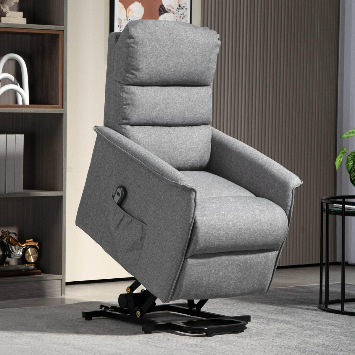 Gray fabric electric lift recliner armchair with footrest, open side view.