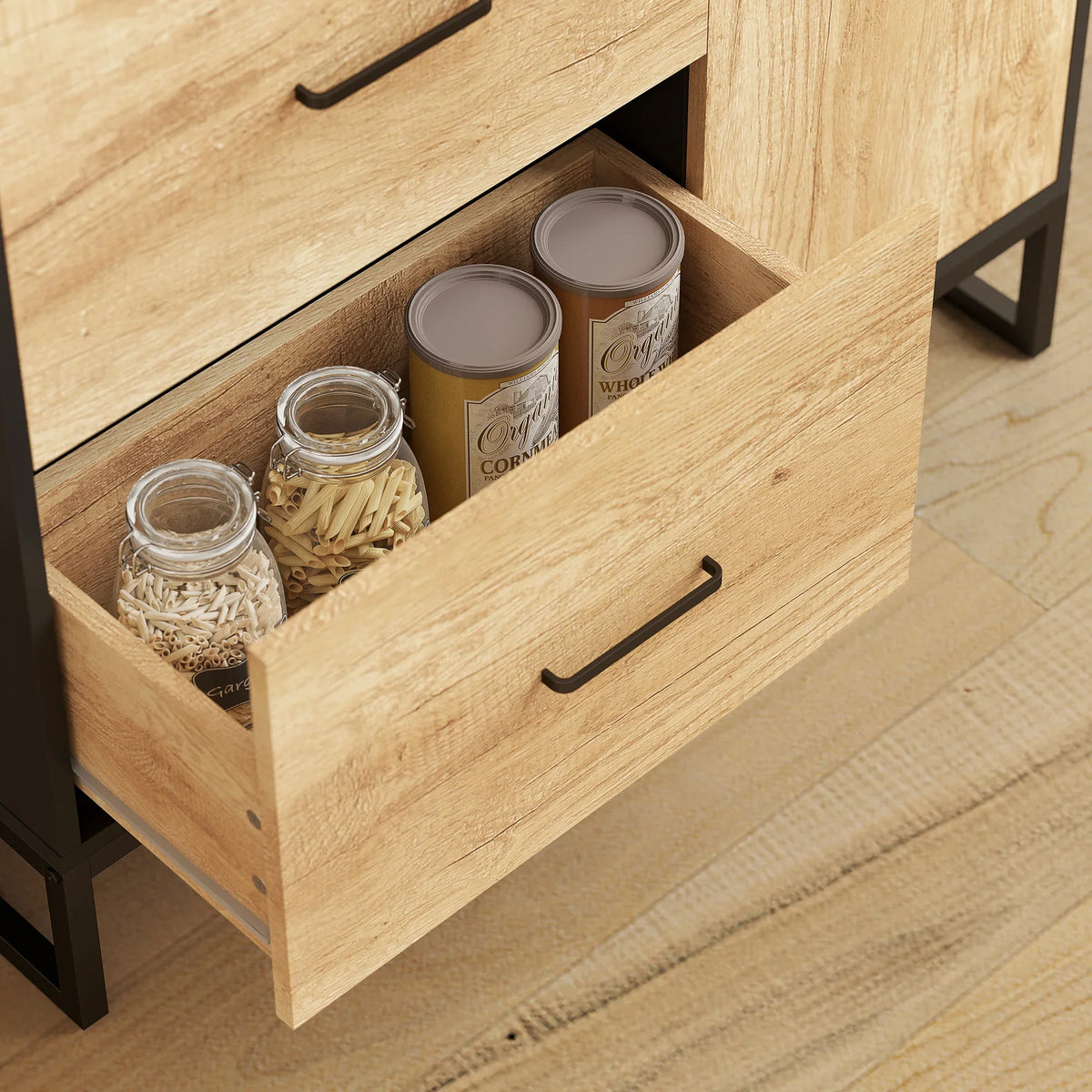 Wood drawer with black pull handles and storage compartments for jars and pantry items