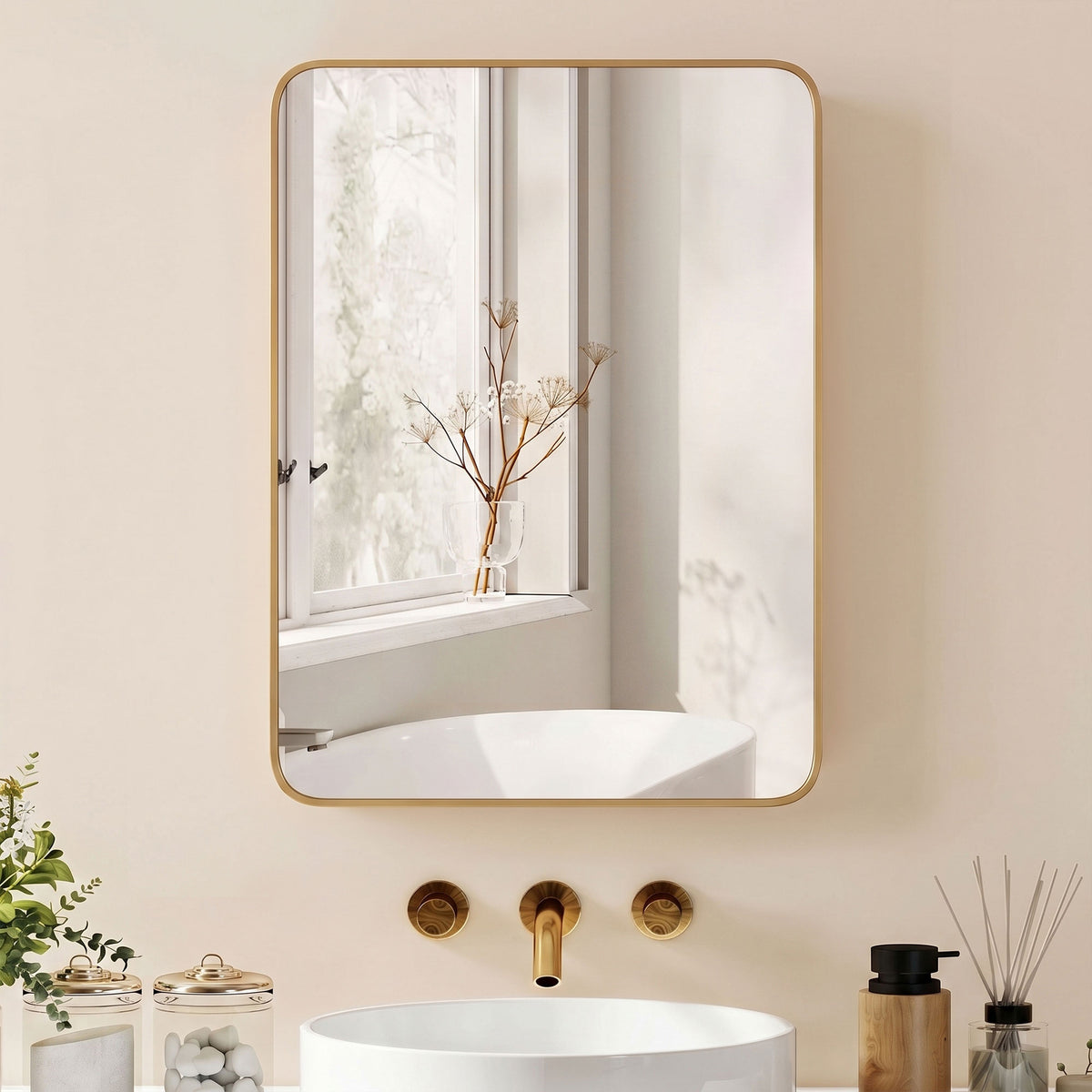 Gold-framed wall mirror cabinet with rounded corners reflecting a bathroom tub area.