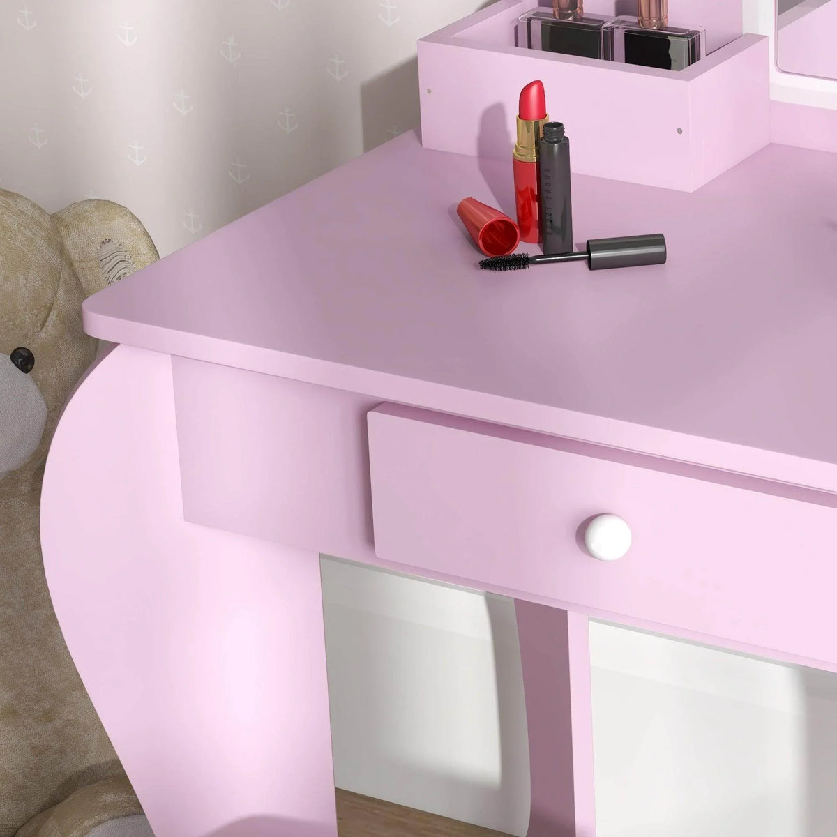 Pink kids vanity table with drawer and smooth front panel, makeup items on tabletop